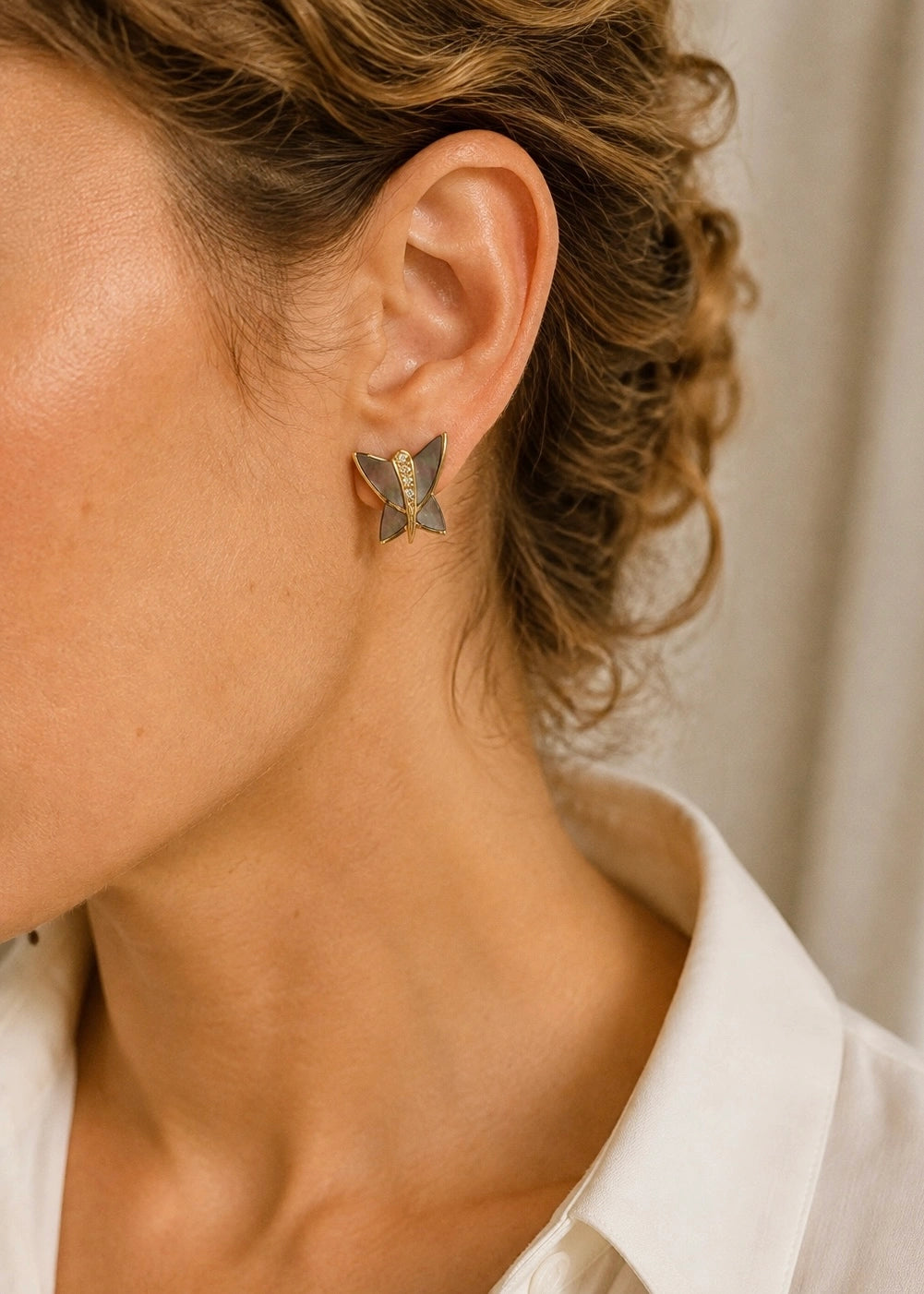 Natural mother of pearl butterfly earrings worn by a woman
