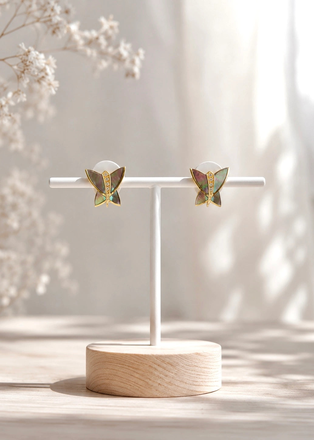 Detail of gold-plated butterfly earrings with natural mother of pearl