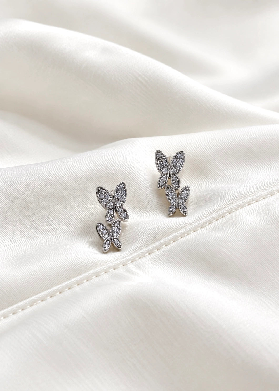 Detail of a sterling silver 925 double butterfly earring with 22 white zircons