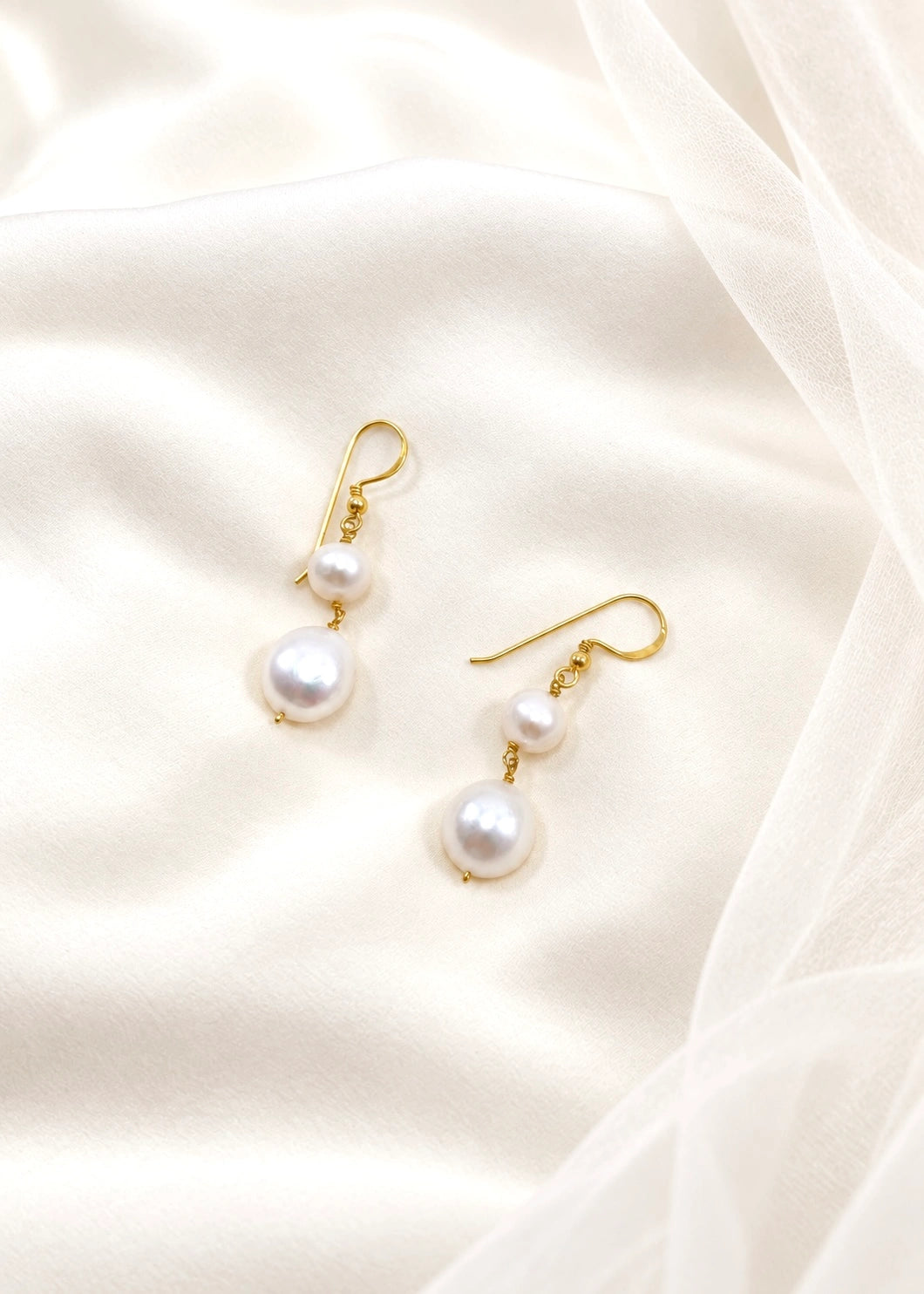 Close-up of an earring with natural white pearls and a 925 hook fastening