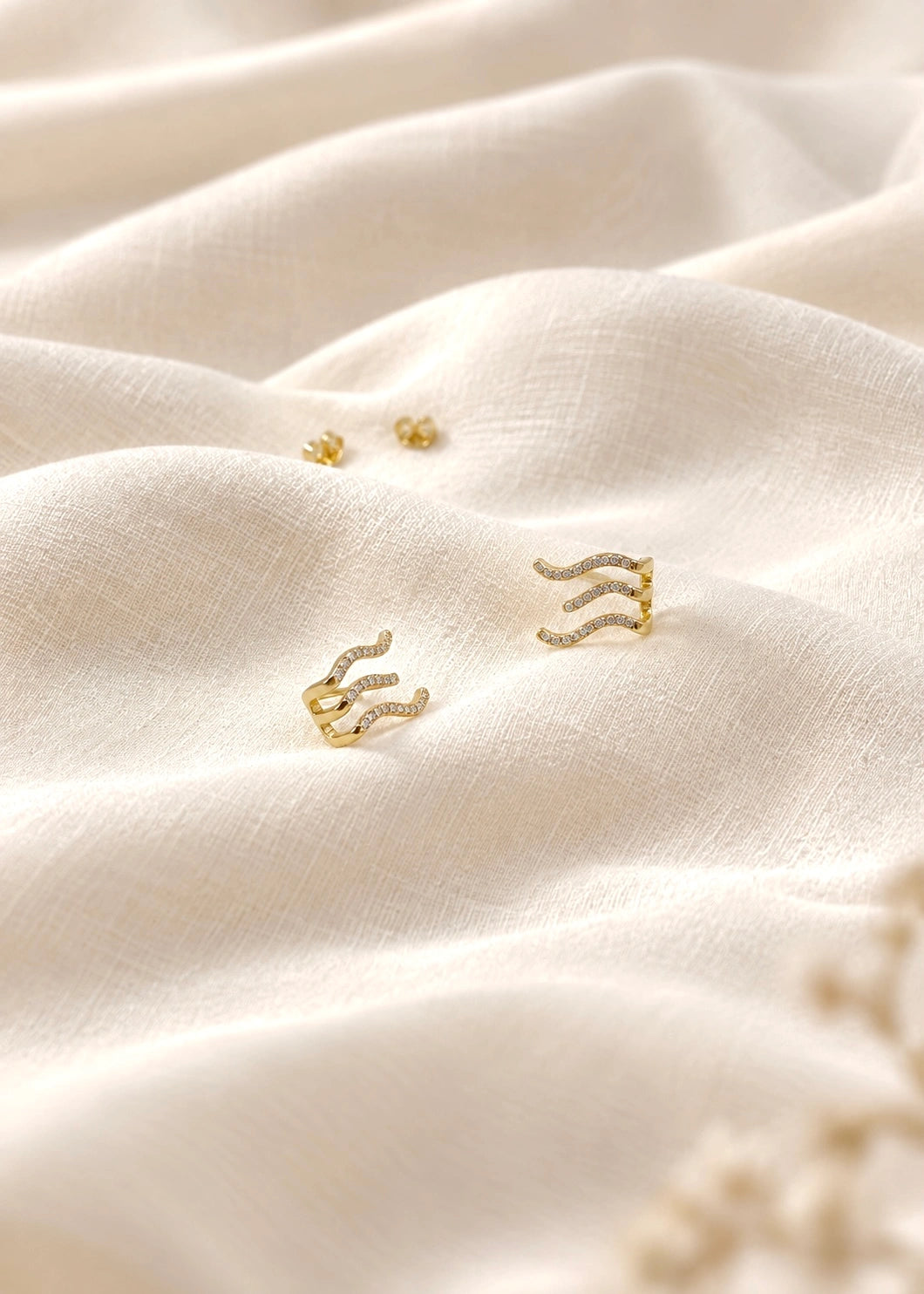 Gold-plated earring with white zircons following the curve of the earlobe