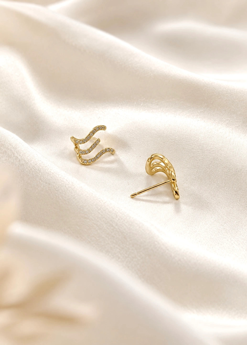 Close-up fit of a wave earring with white zircons on the ear