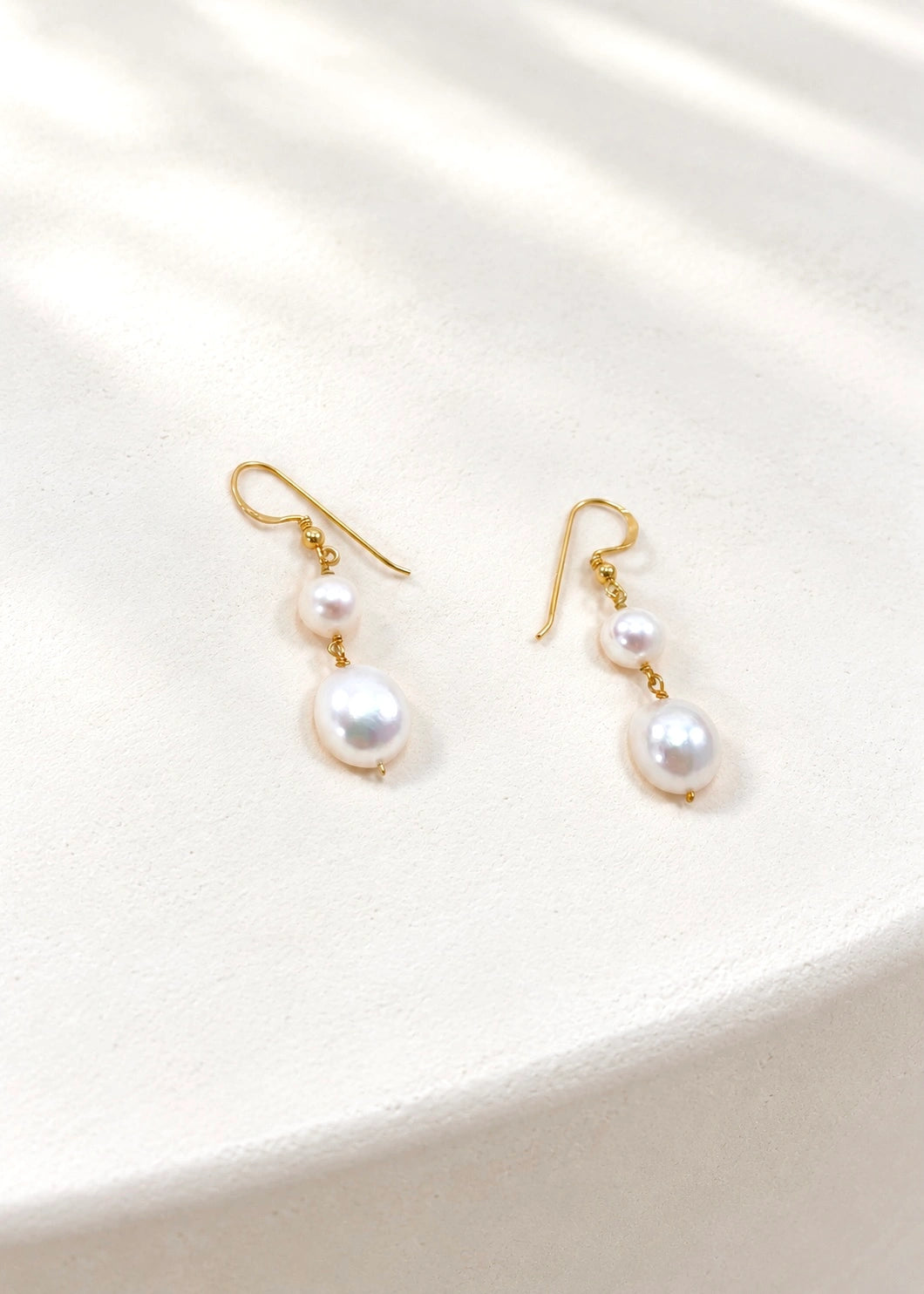 Earrings with two natural white pearls and a slim gold-plated hook