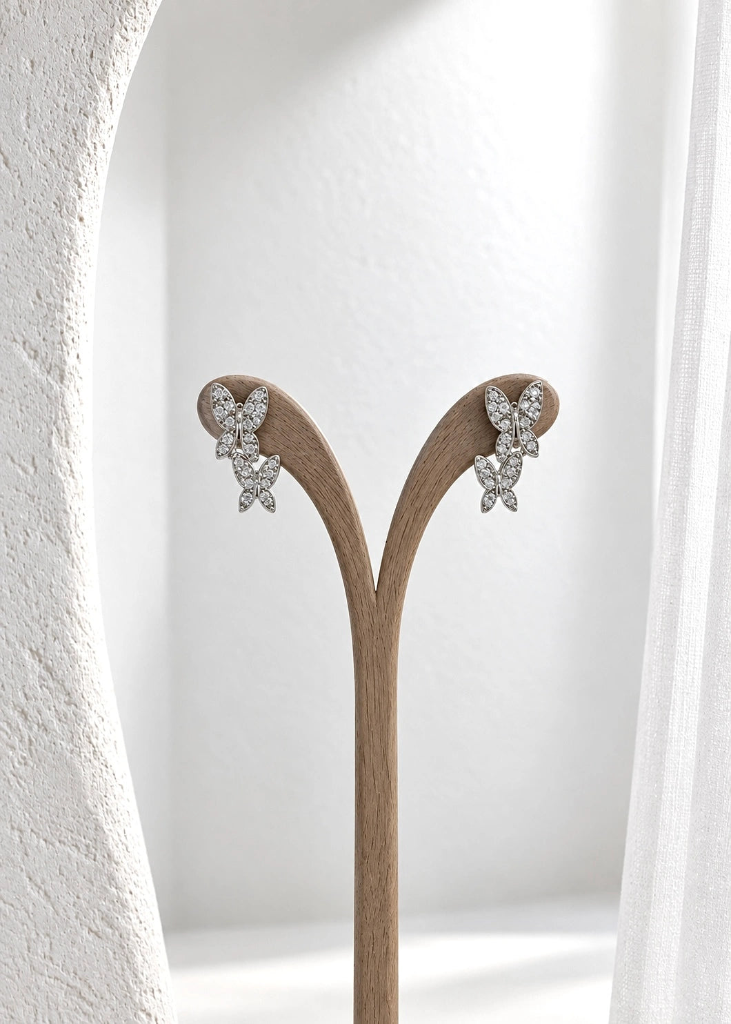 Sterling silver 925 double butterfly earrings with white zircons on a stand